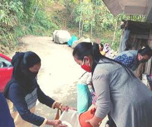 Sanju ('18) distributes food to the poor from her shop.