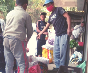 Sanju ('18) distributes food to the poor from her shop.