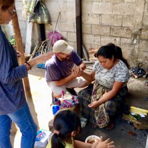 Global Action - Guatemala Coordinators, Jairo and Andrea, pray with Fernando's wife in their kitchen