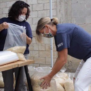 Cherry helps fill bags with rice for distribution.