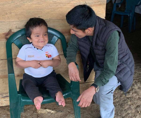 Erick Coc working with a little boy