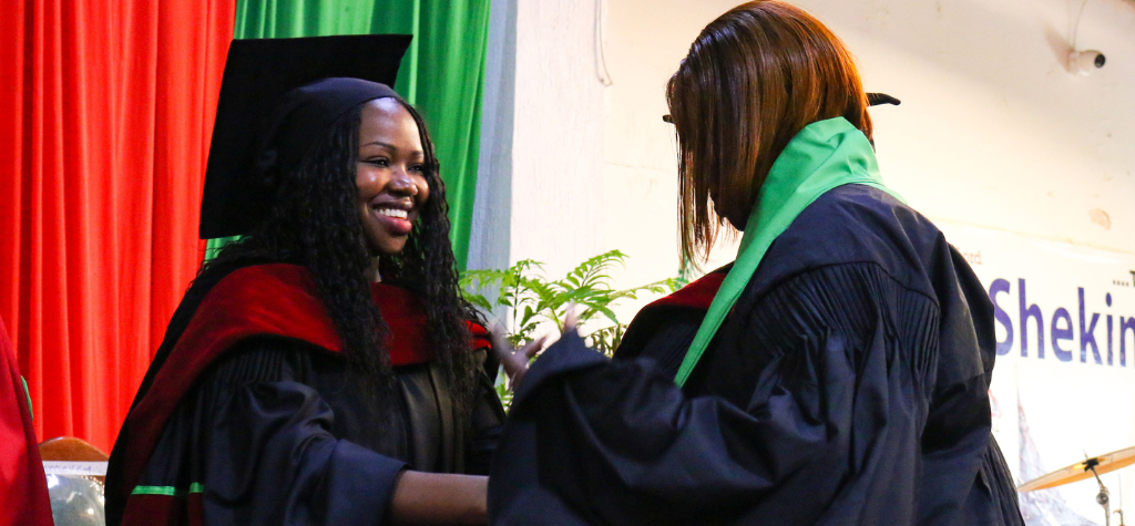 woman at graduation shaking another woman's hand